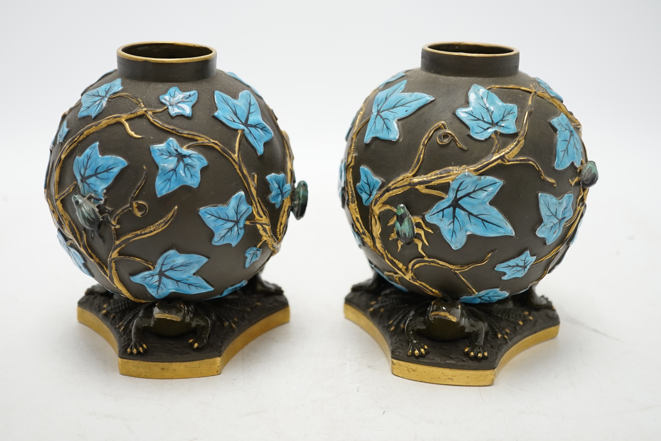 A pair of George Jones Kumassie vases designed by Christopher Dresser, relief moulded designs, frog supports, 14cm. Condition - good